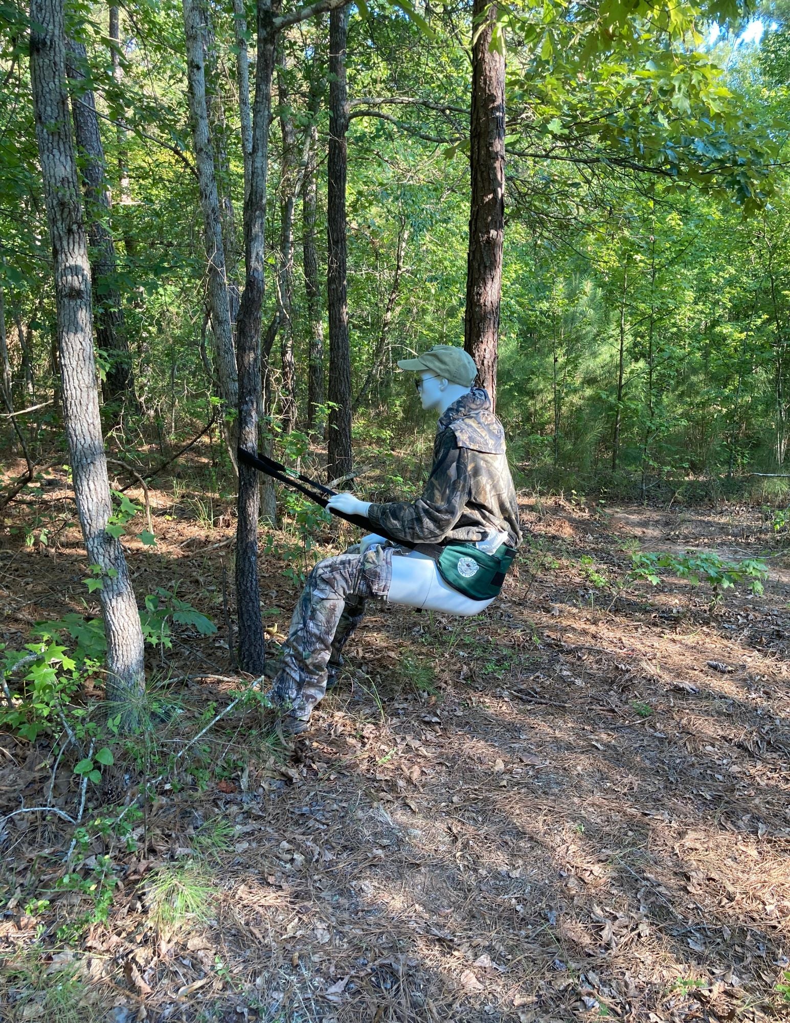 a picture of a mannequin using the krapp strapp tied to a tree